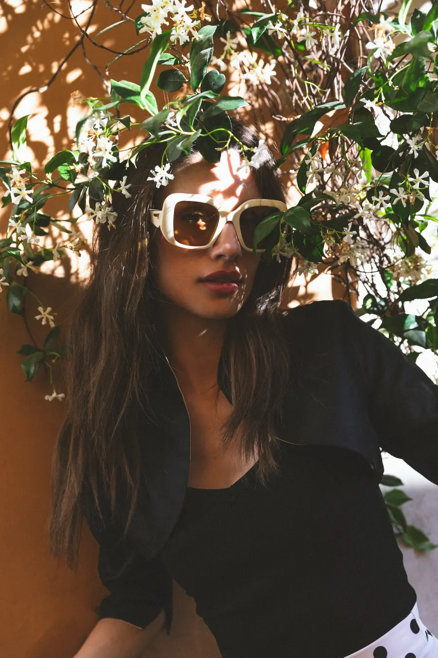 A portrait beneath a jasmine bush in flower