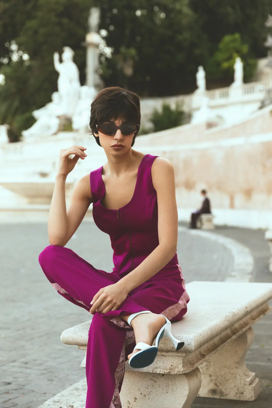 A model sitting on a balustrade, the steps behind her