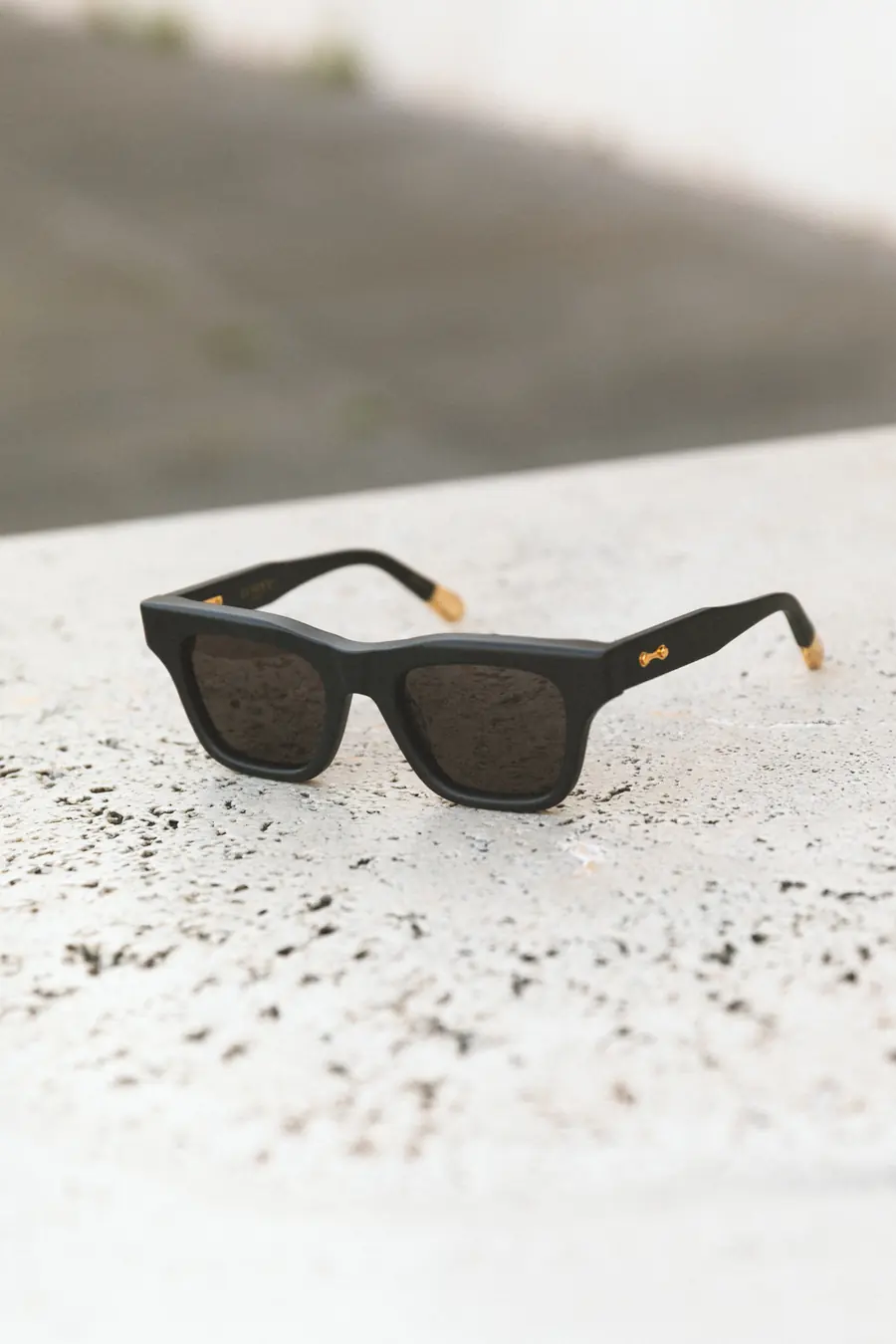 A black frame resting on a block of travertine