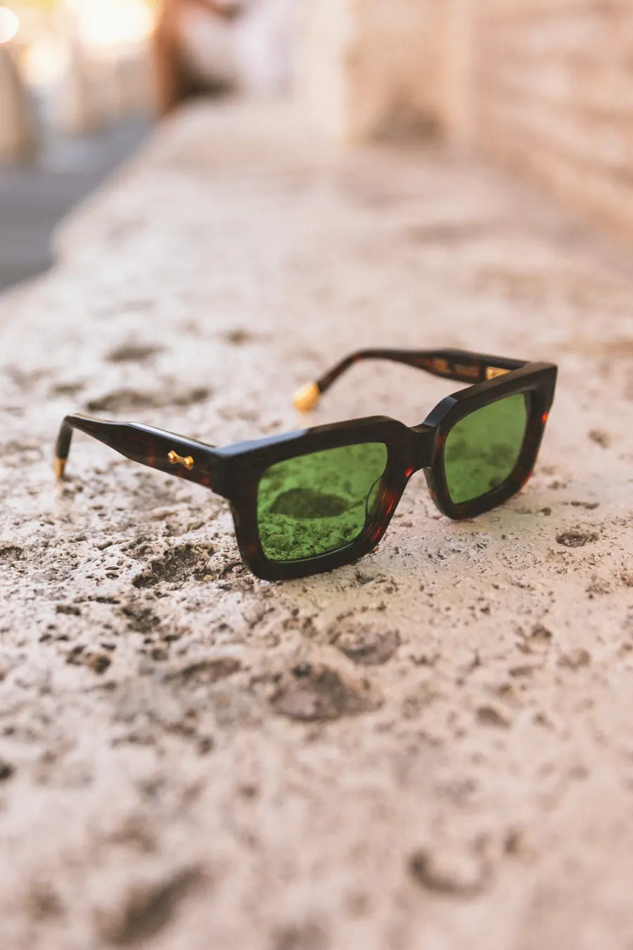 A frame with green lenses on a pale low wall
